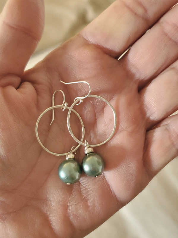 green pearl silver hoop earrings in hand