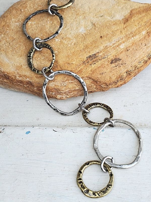 textured chunky silver circle bracelet on a rock