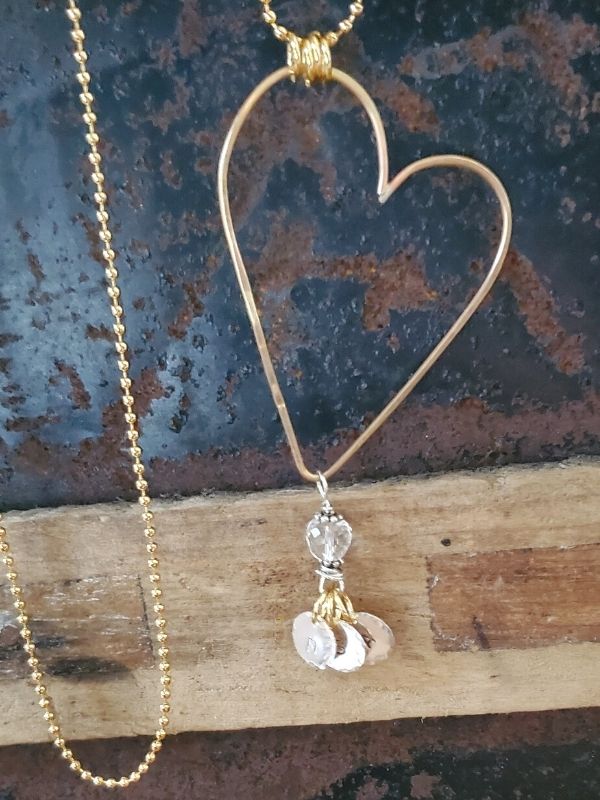 gold heart charm necklace on old wood