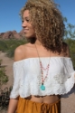 Layered-coral-necklace-with-truquoise-pendant-on-black-model-outdoors