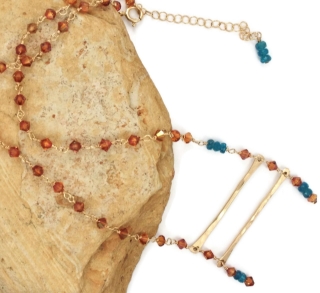 Swarovski crystal gold bar necklace on rock