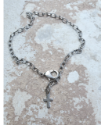 silver cross chain anklet on concrete