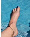 silver cross chain anklet on foot in pool