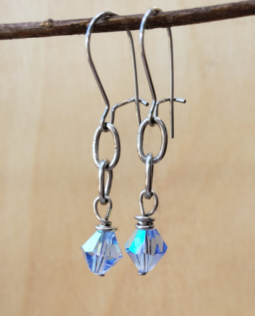 aqua crystal earrings hanging on branch
