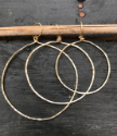 various sized gold  hoop earrings on black background