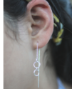 sterling silver circle ear threads hanging from female earlobe