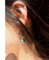 sterling hoop green pearl earring on earlobe and hanging hair