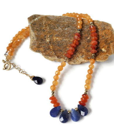 orange  & blue gemstone collar necklace on rock