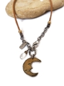 brass moon necklace on rock on white background