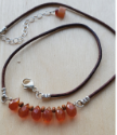 Casual Brown leather orange gemstone necklace on wood
