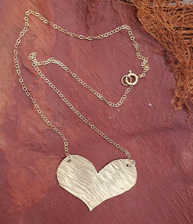 Gold heart delicate chain necklace on texture material