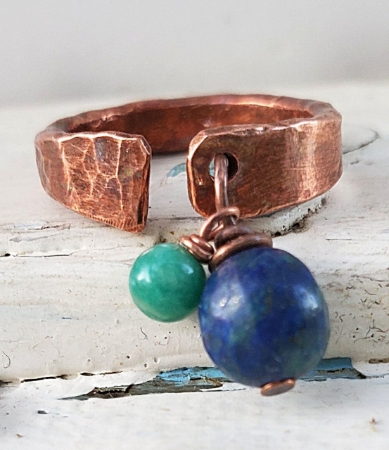 Antimicrobial copper cuff ring with blue gemstone on white distressed background