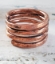hand forged copper coil ring on white distressed wood