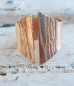 handcrafted bronze crevice ring on white distressed wood
