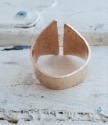 backside of bronze crevice ring on white distressed wood