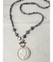 Blue-gray  pearl 1958 Portuguese coin necklace on white distressed wood