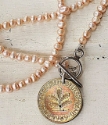 German coin necklace with peach freshwater pearls on white wood