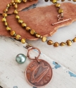 Irish coin pearl necklace on wood