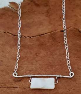 White gemstone siilver bar necklace on wood