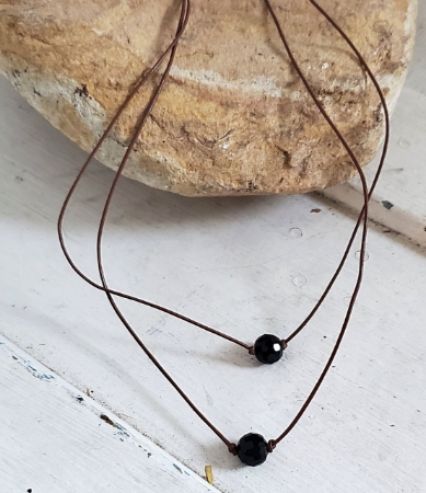 Black onyx leather necklace on a rock