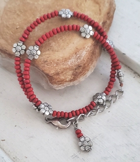Red bead silver flower bracelet on rock