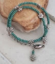 Turquoise wood beads & silver flower bracelet on a rock