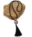 Black and pink gemstone tassel necklace on rock
