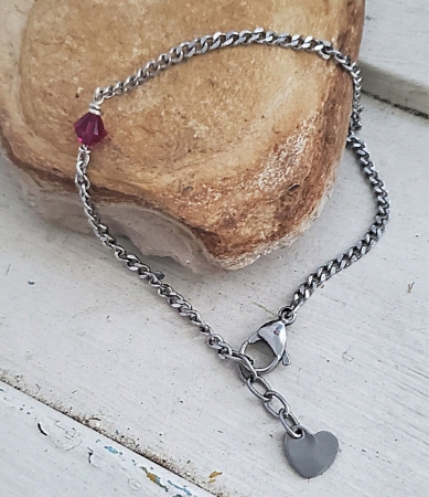 Red crystal silver chain heart anklet on stone rock