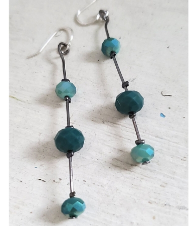 Two tone teal crystal stick earrings on white wood