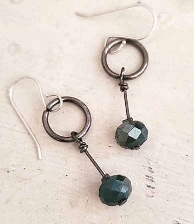 On white wood small gunmetal hoop green crystal earrings