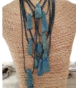 Teal druzy gemstone leather necklaces piled on a textured bust