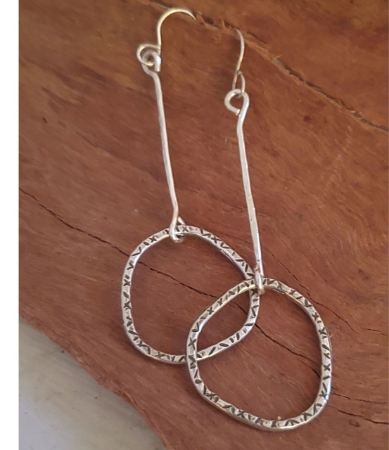 Silver stick hoop earrings on wood