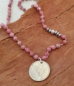 pink gemstone Canadian coin necklace on wood