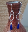 Blue gemstone sterling silver earrings hanging from pottery