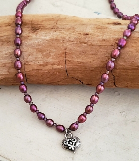 Silver heart purple pearl necklace on wood