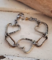 mixed metal triple heart link bracelet on white trunk