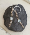 blue stone bronze chain earrings on black rock