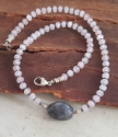 Gray and pink gemstone necklace on wood