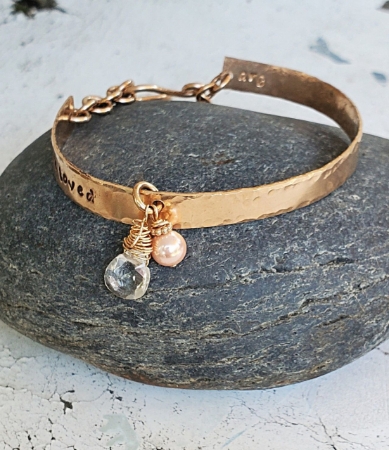 You are Loved bronze pearl crystal bracelet on white distressed wood