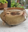 You are Loved bronze pearl crystal bracelet on rock in garden