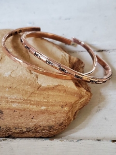 two bronze bracelets on rock