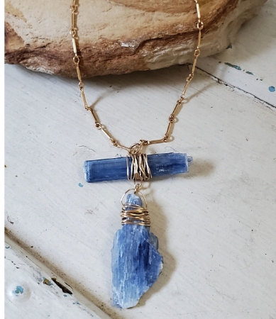 blue kyanite gold chain necklace on rock