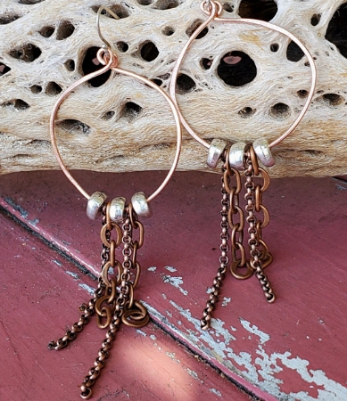 silver and copper hoop chain earrings on distressed red wood