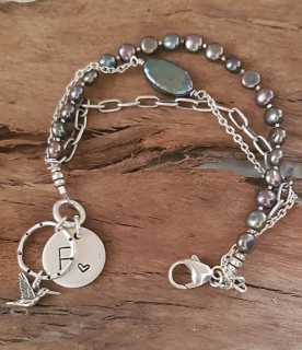 Pearl silver chain hummingbird bracelet on wood