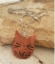 Copper cat face necklace on rock