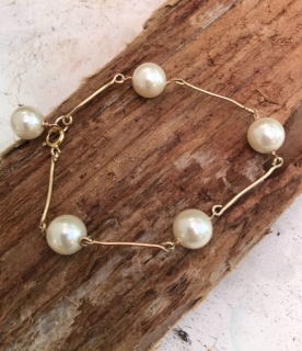 big white pearl gold bar bracelet on wood