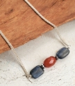 close up blue orange gemstones of necklace on wood