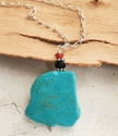 Turquoise pendant silver chain necklace on wood
