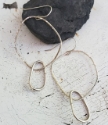 Silver hoop oval earrings on rock