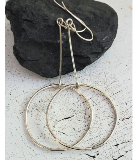 Geometric silver hoop stick earrings on black rock